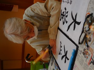 入居者が書道活動に取り組む様子。毛筆で文字を書いている